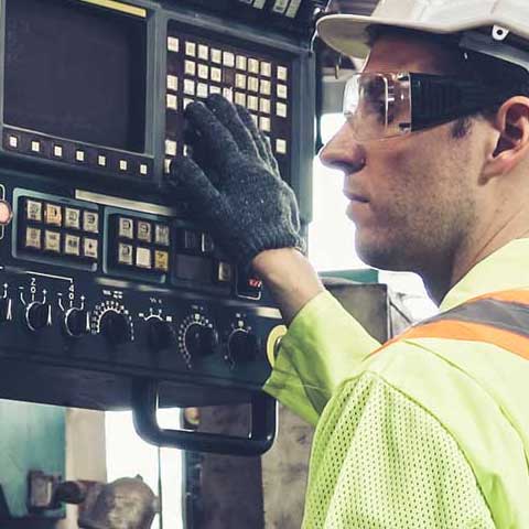 Employee interacts with machine in manufacturing facility